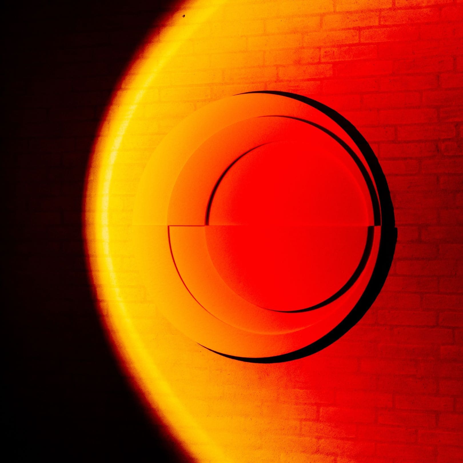 3D light art installation on wall with a vibrant red and orange gradient glow